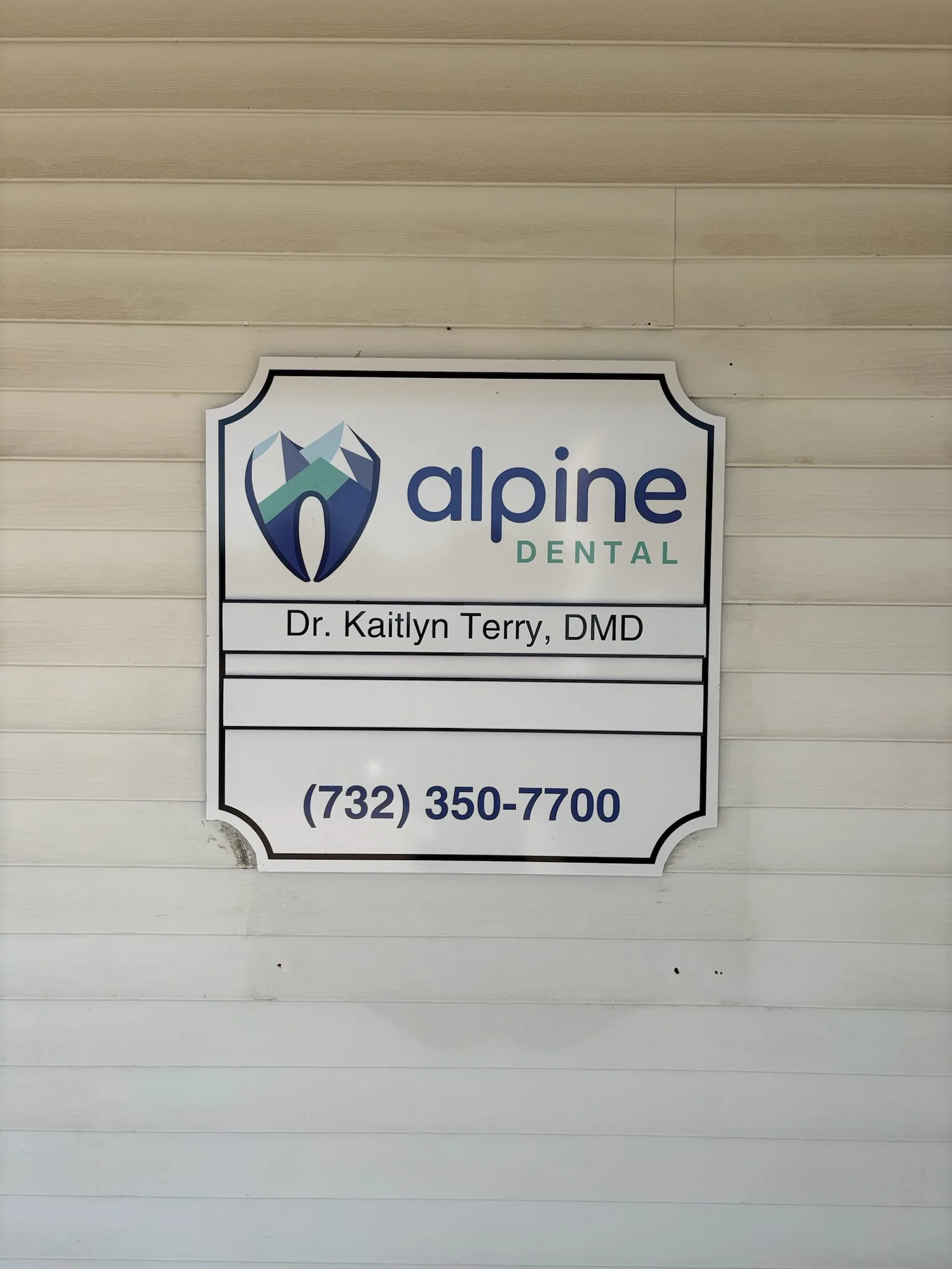 Alpine Dental Manchester exterior sign with office phone number